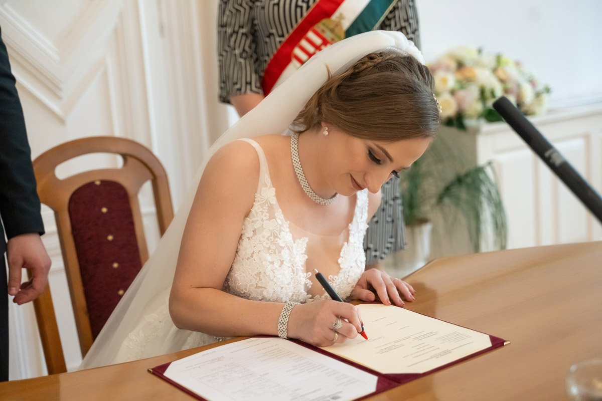 Melinda és Béla aláírja az esküvői fogadalmat a miskolci szertartáson