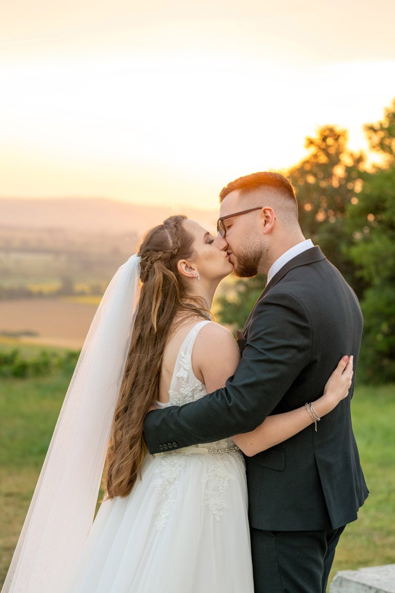 Melinda és Béla naplementés csókja a tarcali esküvői kreatív fotózáson